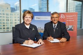 Janet Ecker, President and CEO of the Toronto Financial Services Alliance, and Dr. Tom Corr, President and CEO of Ontario Centres of Excellence, sign a new partnership agreement that will connect Toronto's financial services sector with Ontario's innovation ecosystem.