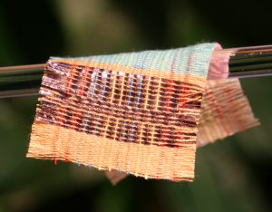 A piece of fabric woven with special strands of material that harvest electricity from the sun and motion.