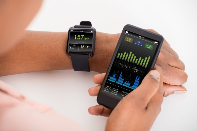 Hand With Mobile And Smartwatch Showing Heartbeat Rate